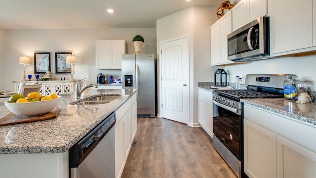 kitchen with sink, appliances with stainless steel finishes, a kitchen island with sink, light hardwood / wood-style floors, and white cabinets