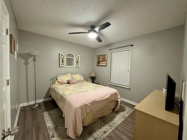 bedroom featuring dark hardwood / wood-style floors, a textured ceiling, and ceiling fan