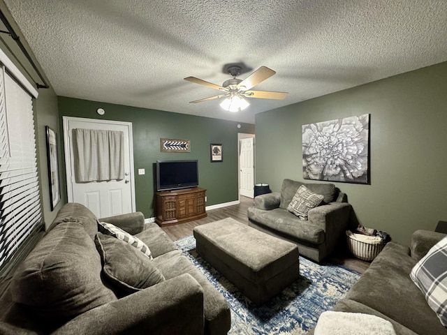 living room with ceiling fan, wood-type flooring, and a textured ceiling