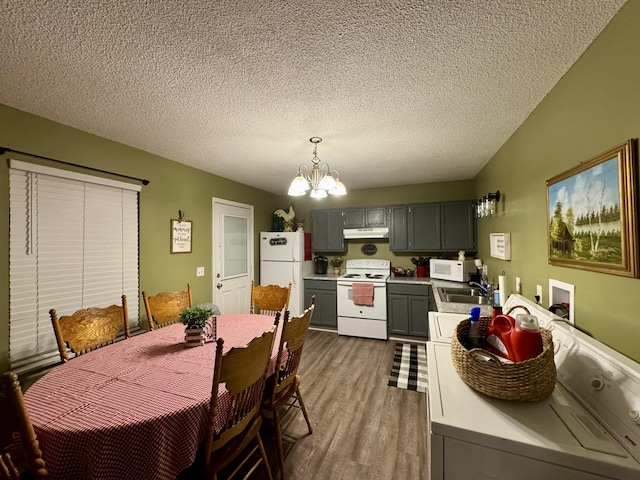 dining area featuring a notable chandelier, sink, dark hardwood / wood-style floors, and a textured ceiling