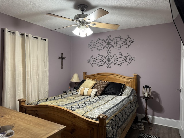bedroom with baseboards, a ceiling fan, dark wood-type flooring, and a textured ceiling