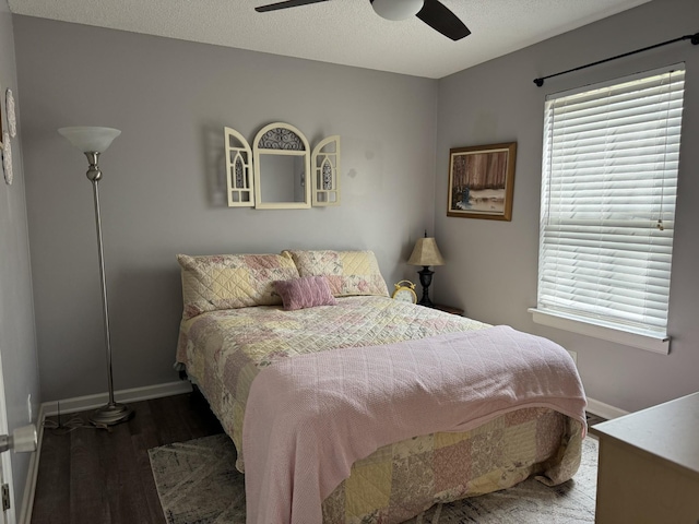 bedroom featuring ceiling fan, baseboards, multiple windows, and wood finished floors
