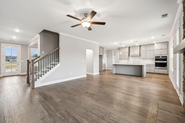 unfurnished living room featuring crown molding, ceiling fan, and hardwood / wood-style flooring