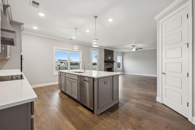 kitchen featuring sink, decorative light fixtures, black electric cooktop, dishwasher, and a kitchen island with sink