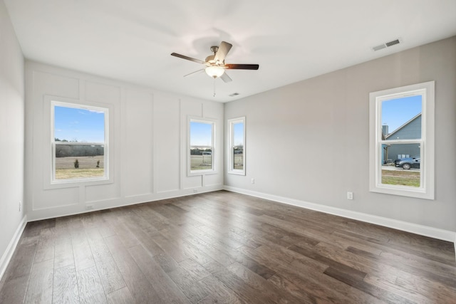 empty room with dark wood-type flooring, ceiling fan, and plenty of natural light