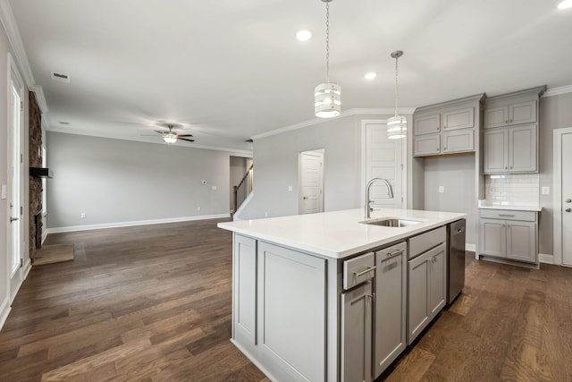 kitchen featuring sink, gray cabinetry, stainless steel dishwasher, ornamental molding, and a kitchen island with sink