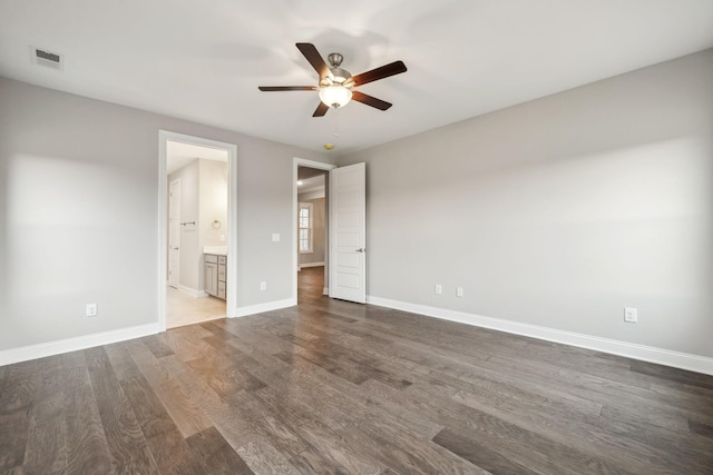 unfurnished bedroom featuring visible vents, wood finished floors, connected bathroom, baseboards, and ceiling fan