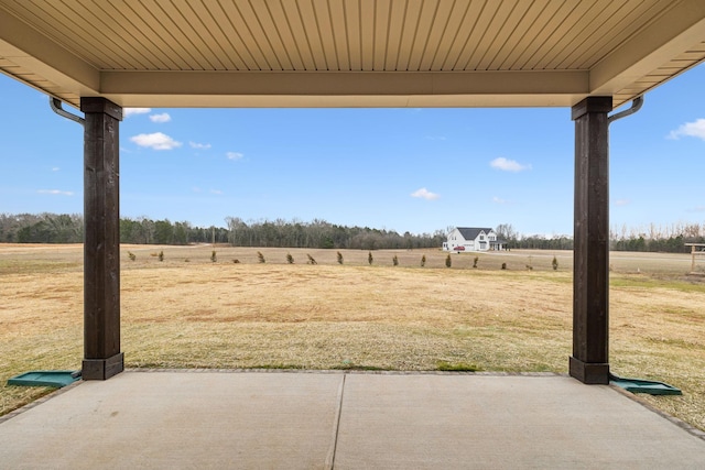 view of yard with a rural view and a patio area