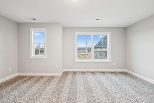 empty room with carpet flooring, baseboards, and visible vents