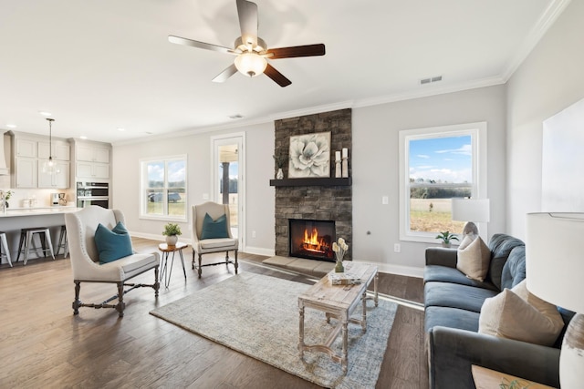 living room with crown molding, light wood-style flooring, and plenty of natural light