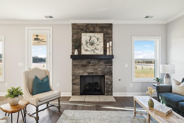 living area with visible vents, crown molding, baseboards, and wood finished floors