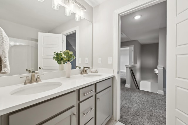 bathroom with double vanity, baseboards, and a sink