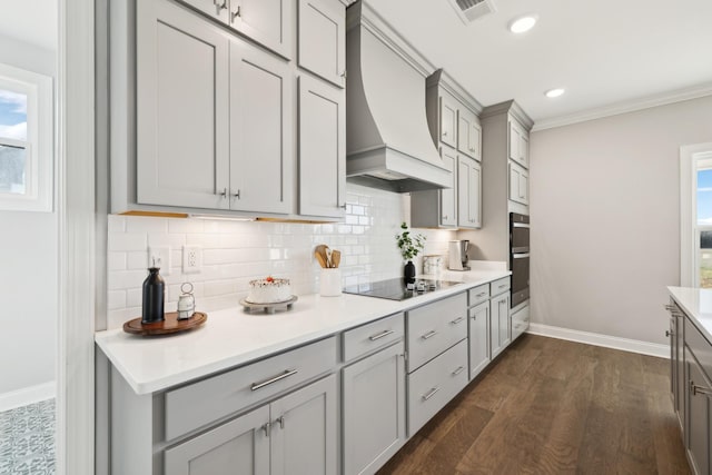 kitchen featuring visible vents, gray cabinetry, premium range hood, plenty of natural light, and black appliances