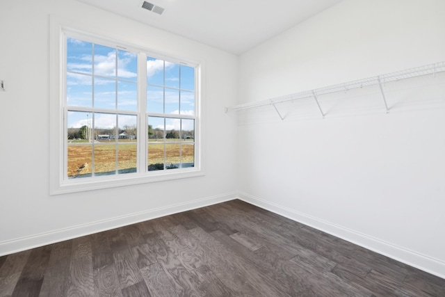 interior space featuring dark wood-style floors, visible vents, and baseboards