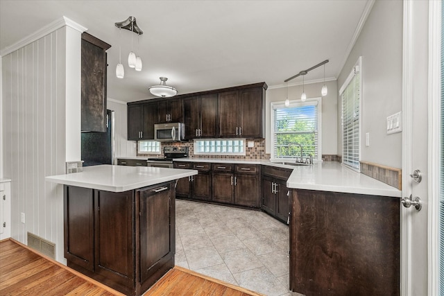515 E 4th St, Cookeville, TN 38501 - kitchen with stainless steel appliances, dark brown cabinets, crown molding, a peninsula, and light countertops