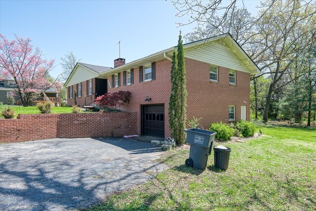 515 E 4th St, Cookeville, TN 38501 - view of property exterior with an attached garage, driveway, a chimney, brick siding, and a lawn