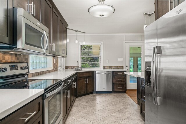 515 E 4th St, Cookeville, TN 38501 - kitchen featuring stainless steel appliances, crown molding, decorative backsplash, dark brown cabinetry, and light countertops