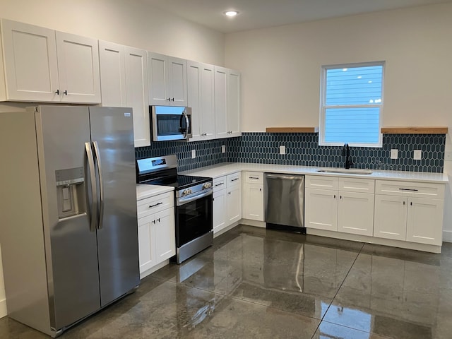 kitchen with white cabinetry, sink, backsplash, and stainless steel appliances