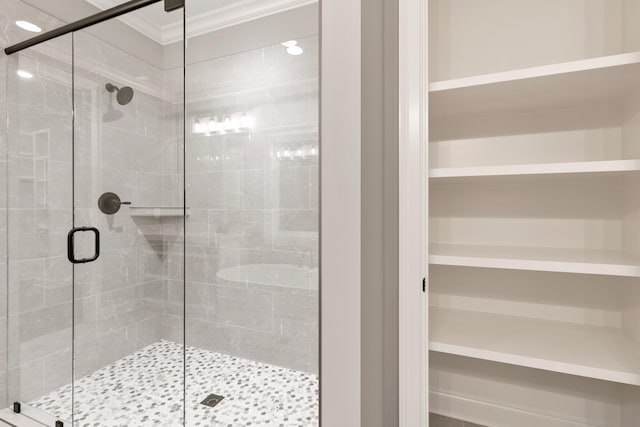 bathroom with ornamental molding and a shower with shower door