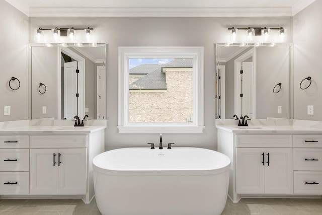 bathroom with vanity, ornamental molding, and a bathtub