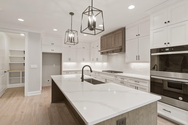 kitchen featuring appliances with stainless steel finishes, a large island, sink, and white cabinets