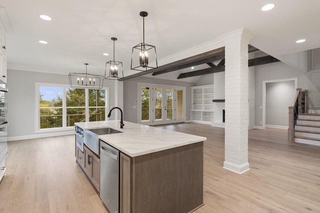 kitchen with sink, white cabinetry, hanging light fixtures, stainless steel appliances, and light stone countertops