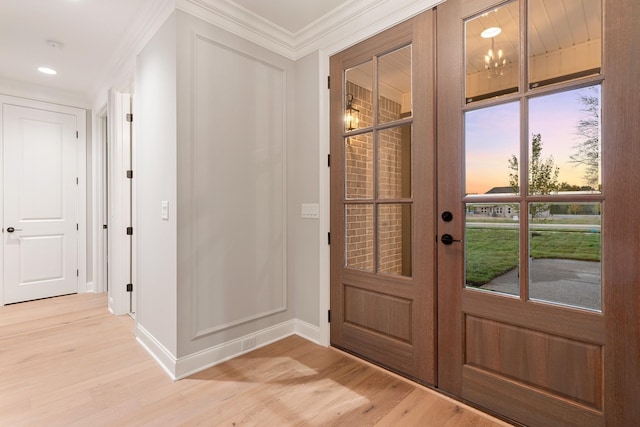 doorway to outside with ornamental molding, light hardwood / wood-style floors, and french doors