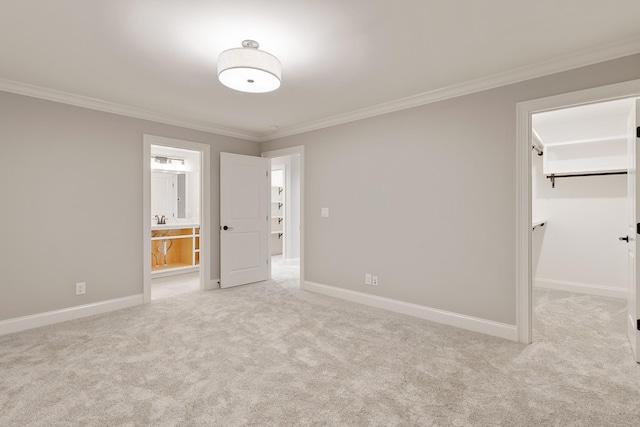 unfurnished bedroom featuring connected bathroom, crown molding, a walk in closet, light carpet, and a closet