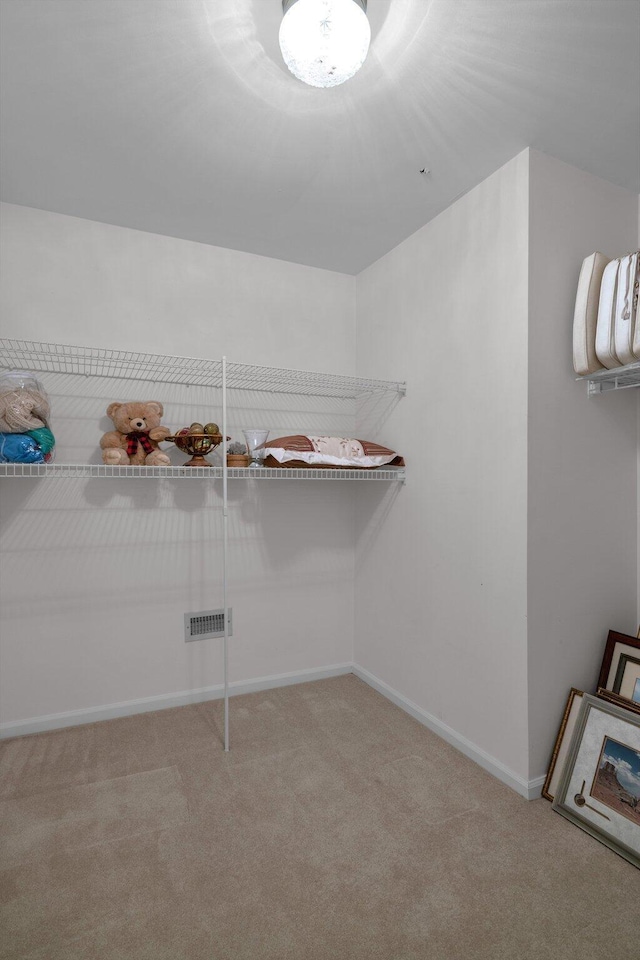 walk in closet featuring light carpet