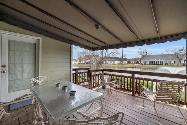 wooden deck with outdoor dining space, a water view, and a residential view