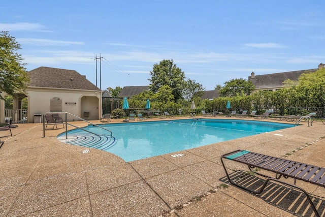 community pool featuring fence and a patio