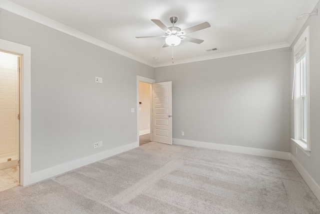 empty room featuring ornamental molding, light colored carpet, and ceiling fan