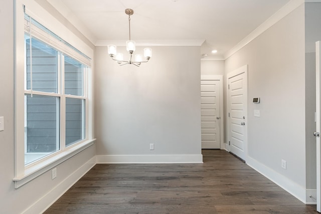 spare room featuring a notable chandelier, crown molding, and dark wood-type flooring