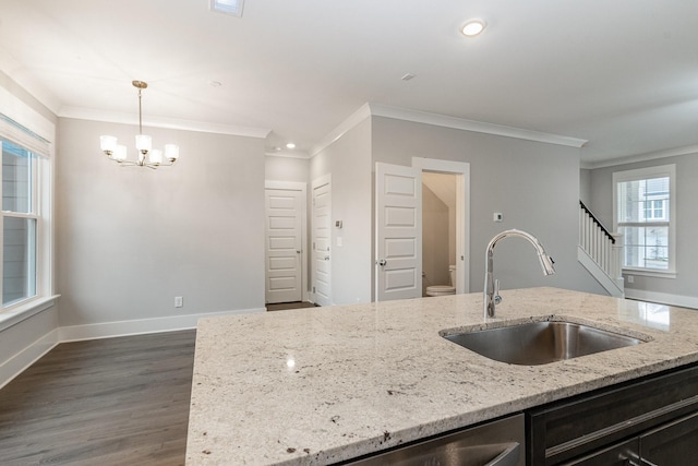 kitchen featuring sink, crown molding, dark wood-type flooring, light stone counters, and decorative light fixtures