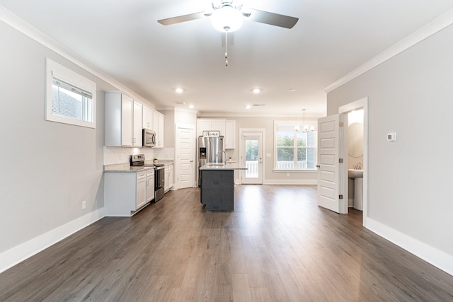 kitchen featuring stainless steel appliances, a center island, tasteful backsplash, ornamental molding, and dark hardwood / wood-style flooring