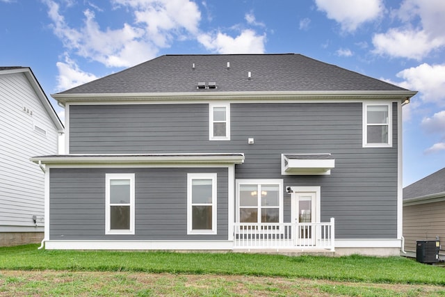 back of house with a yard and central air condition unit