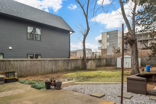 view of yard with a storage shed and a patio