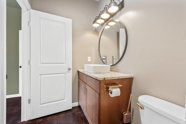 bathroom featuring vanity, concrete flooring, and toilet