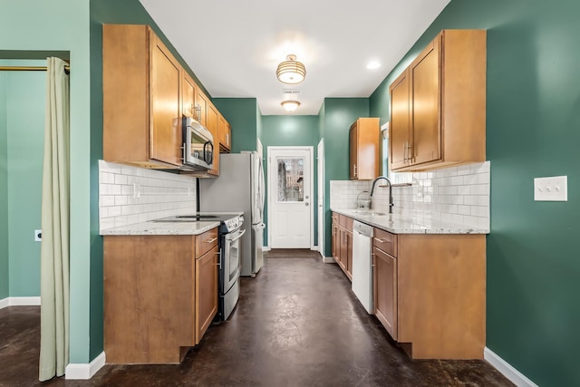 kitchen with stainless steel appliances, sink, backsplash, and light stone counters