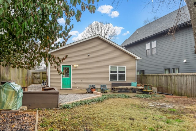 rear view of property featuring a lawn