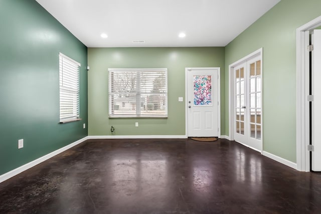 foyer entrance featuring concrete flooring and french doors