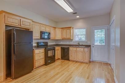 kitchen with light brown cabinetry, sink, light hardwood / wood-style flooring, and black appliances