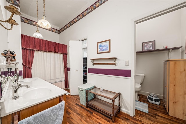 bathroom featuring hardwood / wood-style flooring, ornamental molding, vanity, and toilet