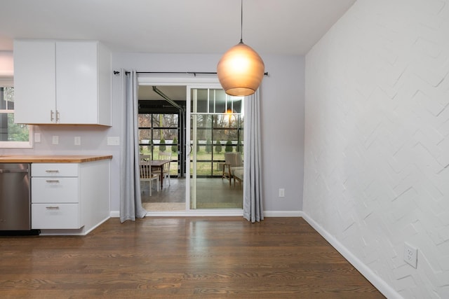 unfurnished dining area with dark wood-type flooring