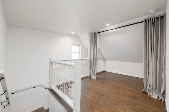 stairway with hardwood / wood-style flooring and vaulted ceiling