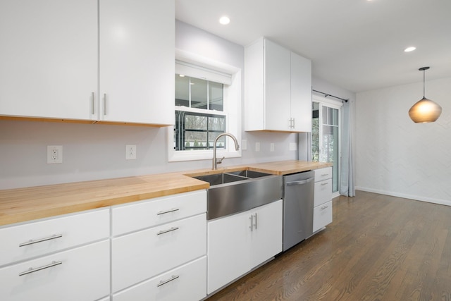 kitchen featuring wooden counters, dishwasher, hanging light fixtures, and white cabinets