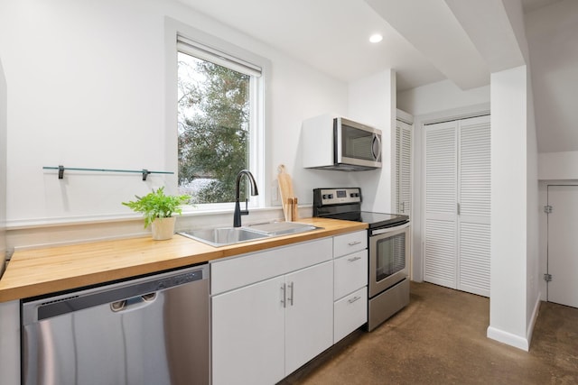 kitchen featuring white cabinetry, appliances with stainless steel finishes, sink, and wooden counters