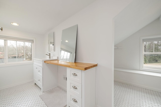 bathroom with vanity and lofted ceiling