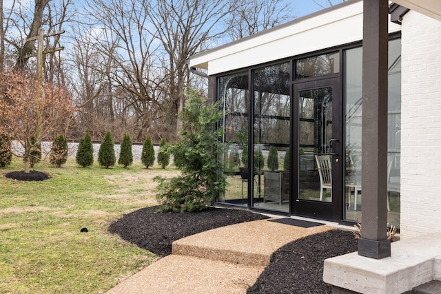 property entrance with a lawn