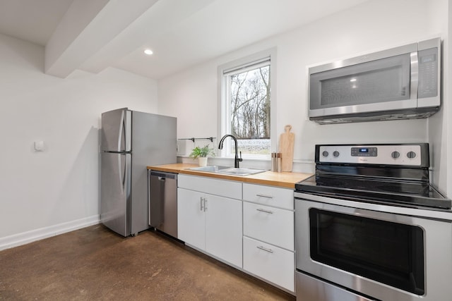 kitchen with white cabinetry, sink, wood counters, and appliances with stainless steel finishes